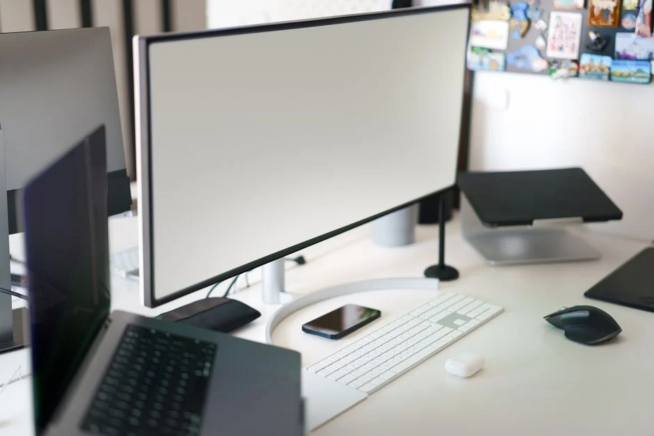High-angle view of a stylish work desk featuring dual monitors, keyboard, mouse, and modern accessories.